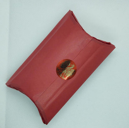 Pillow Box Wrapped in Red Tissue paper with a Polish sticker